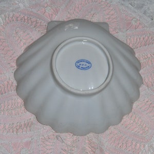 K&ouml;nnte beinhalten: Wei&szlig;e Porzellan-Muschel-Schale mit einem blauen und wei&szlig;en Stempel auf der Unterseite, der "Porcelaine P.F.C. De France" lautet.