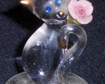 Figurita de gato de cristal en miniatura vintage sentada sobre pedestal, gatito con ojos de cristal azul y rosa rosa.