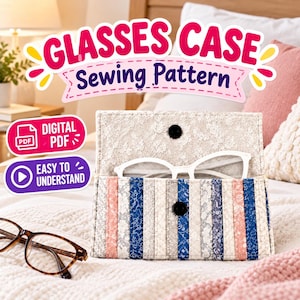 May include: A rectangular fabric glasses case featuring vertical stripes in shades of blue, pink, and cream with a lace-like overlay. The case has a flap with a black snap closure and contains white glasses. Text reads: GLASSES CASE Sewing Pattern.