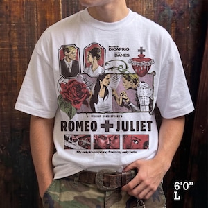 Pu&ograve; includere: Una t-shirt bianca a maniche corte con una stampa grafica del film William Shakespeare's Romeo + Juliet. Il design include ritratti di Leonardo DiCaprio e Claire Danes, una rosa rossa, un cuore sacro e il testo My only love sprung from my only hate.