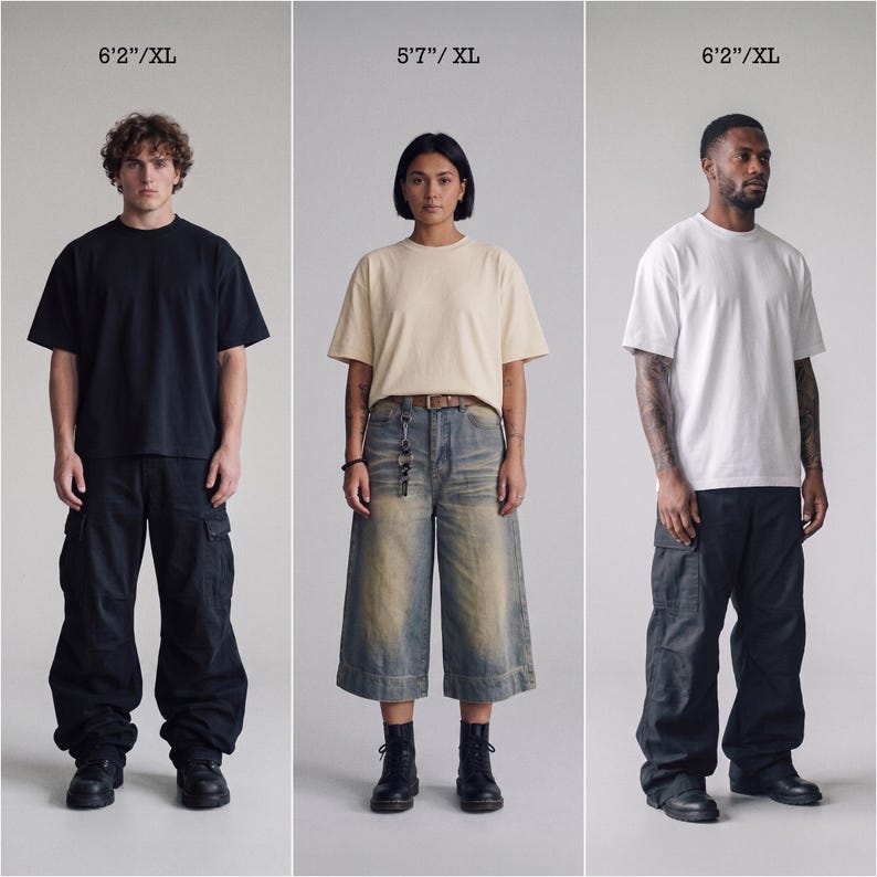 Pu&ograve; includere: Tre persone indossano magliette a maniche corte con girocollo in nero, crema e bianco. Le figure a sinistra e a destra indossano pantaloni cargo neri, mentre la figura centrale indossa culotte in denim blu. Le etichette di testo indicano 6'2"/XL e 5'7"/XL.