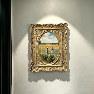 Pode incluir: Uma moldura retangular em tom dourado com detalhes ornamentados de flores e volutas em relevo rodeia uma pintura a óleo de formato oval. A obra mostra duas figuras em pé num campo de flores silvestres sob um céu azul brilhante e nublado.
