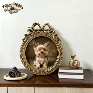 Pode incluir: Uma moldura redonda e dourada, ornamentada com um laço decorativo no topo e uma borda texturizada. A moldura contém o retrato de um pequeno Yorkshire Terrier castanho e preto. O texto Grandma Frame é visível no canto superior esquerdo.