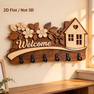 May include: A wooden wall-mounted key holder featuring the text "Welcome" in script, a house icon with a heart cutout, and floral accents. The piece includes six black metal hooks and is labeled with the text "2D Flat / Not 3D".