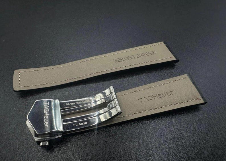 Pu&ograve; includere: Un cinturino per orologio con chiusura in acciaio inossidabile e due cinturini in pelle beige. La chiusura &egrave; contrassegnata con "TAG Heuer", "STAINLESS STEEL" e "FC 5030". I cinturini in pelle sono contrassegnati con "GENUINE LEATHER" e "TAG Heuer".