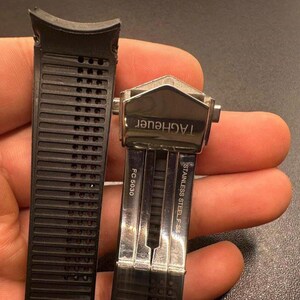 Pu&ograve; includere: Cinturino per orologio in gomma nera con chiusura in acciaio inossidabile. La chiusura &egrave; contrassegnata con "TAGHeuer" e "STAINLESS STEEL F 95". Il cinturino ha un design a coste ed &egrave; contrassegnato "FC 5030".