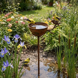 May include: A rustic, metal bird bath with a shallow bowl filled with water, supported by a slender, vertical rod. Three yellow and black birds perch on the bowl and nearby, with a lush garden background filled with flowers and greenery.