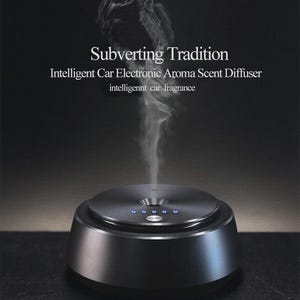 Puede incluir: Difusor de aroma para coche negro con acabado metálico. El dispositivo tiene una parte superior circular con luces indicadoras azules y emite una corriente de vapor. El texto de la imagen dice "Subverting Tradition" y "Intelligent Car Electronic Aroma Scent Diffuser".
