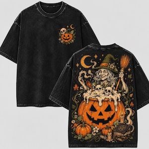 May include: A black acid-wash t-shirt featuring a small graphic on the front chest of a jack-o'-lantern and skull. The back displays a large, detailed illustration of a witch stirring a bubbling cauldron inside a pumpkin with skulls.