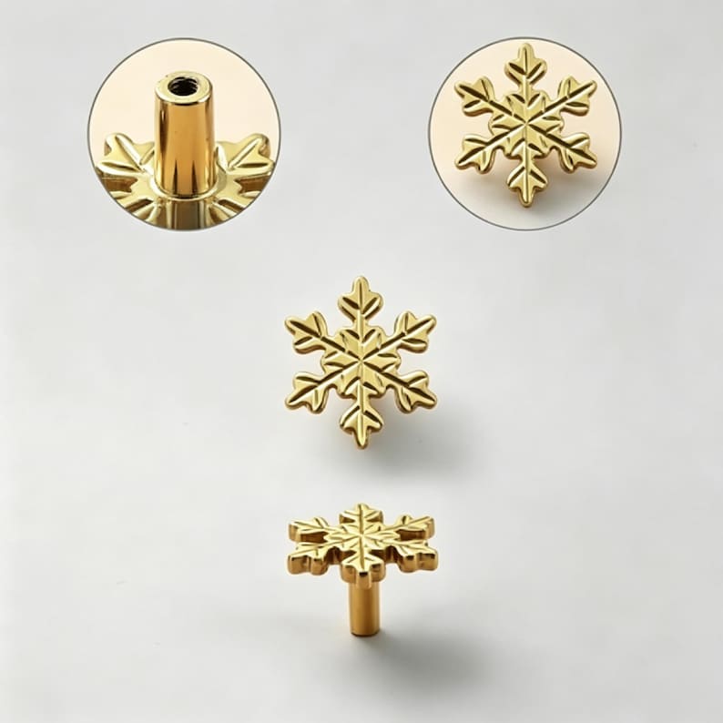 May include: Gold-colored snowflake cabinet knobs. The knobs are in the shape of a six-pointed snowflake. The image shows the knobs from different angles, including a close-up of the stem and the snowflake design. The knobs are made of metal.