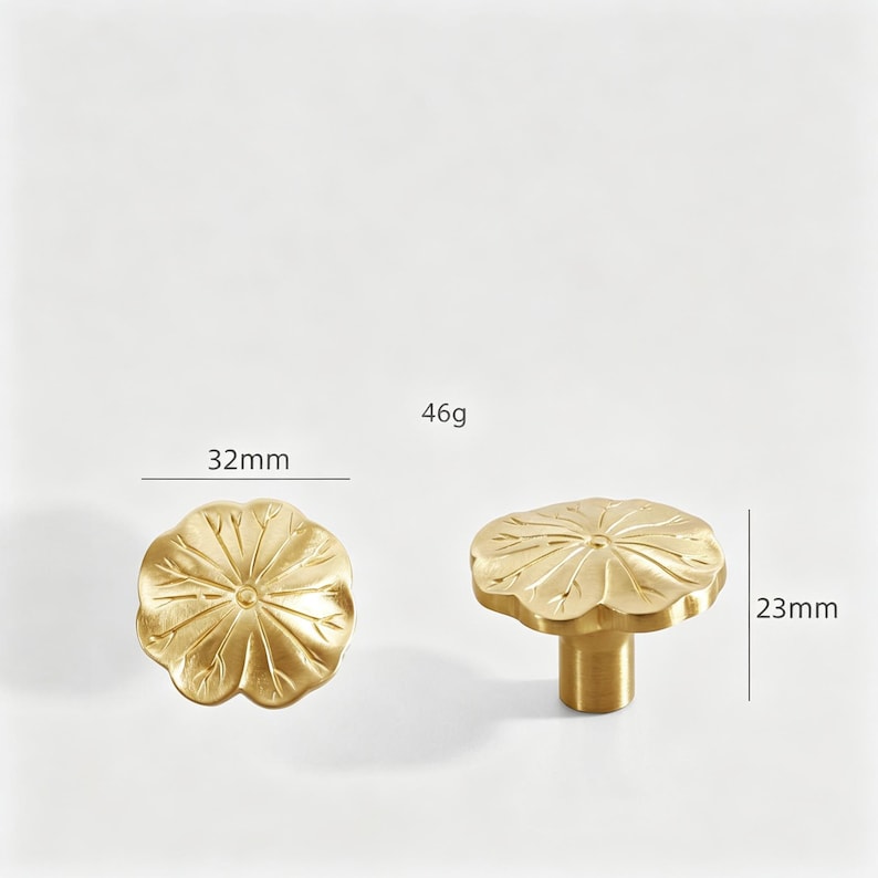 K&ouml;nnte beinhalten: Zwei goldfarbene Schrankkn&ouml;pfe mit Lotusbl&uuml;ten-Design. Ein Knopf wird von oben gezeigt und misst 3,2 cm im Durchmesser. Der andere Knopf wird von der Seite gezeigt und ist 2,3 cm hoch. Das Gewicht betr&auml;gt 46g.