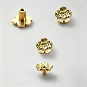 May include: Four brass flower-shaped cabinet knobs. The knobs have a detailed floral design and are in various orientations, including one with a stem. The hardware is set against a white background.
