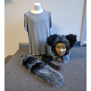 May include: A gray t-shirt, a black and gray furry tail, and a black and gray furry animal head with a black headband. The animal head has a white face with closed eyes.