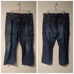 May include: A pair of dark blue denim cargo pants with a red and white label on the back pocket.