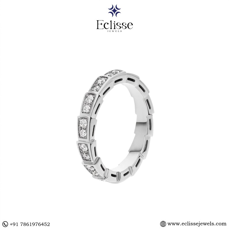 Op de afbeelding: Een zilveren ring met een herhalend patroon van rechthoekige secties, elk bezet met kleine, sprankelende diamanten. De ring heeft een modern, geometrisch ontwerp. De merknaam "Eclisse Jewels" is zichtbaar.