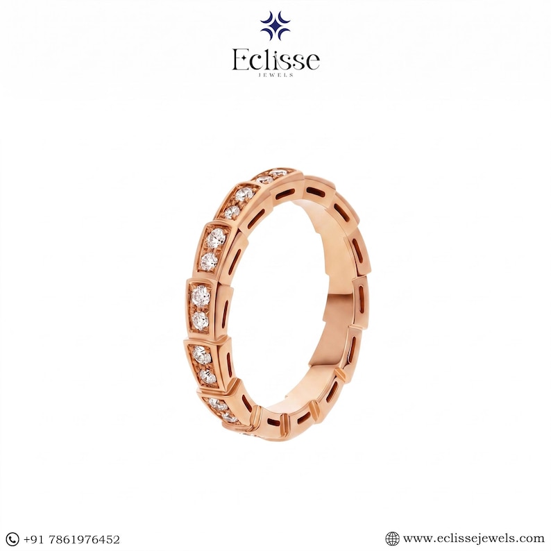 Op de afbeelding: Ros&eacute;gouden ring met een geometrisch ontwerp, met kleine, sprankelende edelstenen. De ring is een bandstijl, met een herhalend patroon van rechthoekige en vierkante vormen. De ring wordt op een witte achtergrond weergegeven. De merknaam "Eclisse Jewels" staat bovenaan.