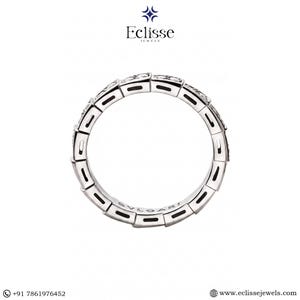 Op de afbeelding: Een zilveren ring met een geometrisch ontwerp, met kleine, sprankelende stenen. De ring is cirkelvormig en heeft het woord "BVLGARI" aan de binnenkant gegraveerd. De ring staat tegen een witte achtergrond.