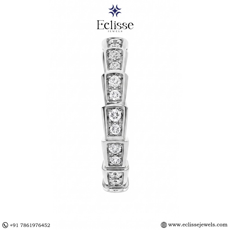 Op de afbeelding: Een zilveren ring met een segmentontwerp, elk segment gezet met meerdere heldere, ronde edelstenen. De ring is van Eclisse Jewels. De achtergrond is effen wit.