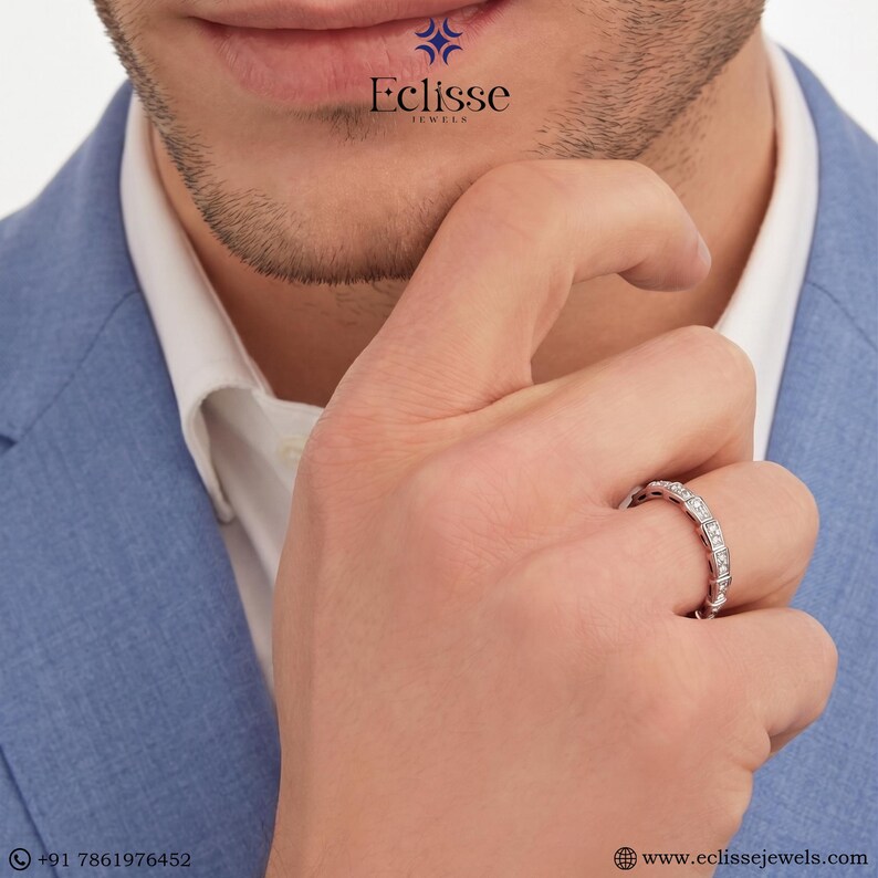 Op de afbeelding: Een zilveren ring met meerdere kleine, rechthoekig geslepen edelstenen. De ring zit om de vinger van een persoon. De afbeelding bevat de tekst "Eclisse Jewels" en een websiteadres.