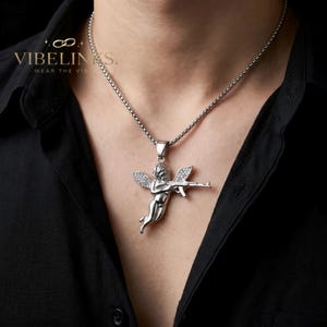 Close-up of a silver tone stainless steel angel pendant necklace featuring a Cupid figure in a flying pose with iced-out cubic zirconia wings, detailed face and body casting, 60cm box chain included, ideal for streetwear fashion.
