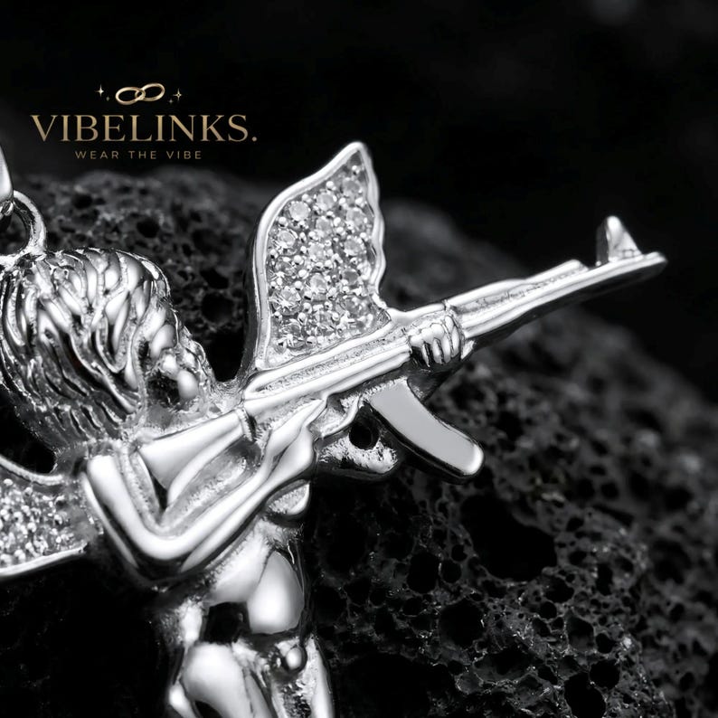 Iced-out Cupid angel pendant necklace in gold tone stainless steel, featuring pavé set cubic zirconia crystals across the wings, dynamic flying angel pose, 60cm stainless steel box chain, perfect for hip hop and streetwear styling.