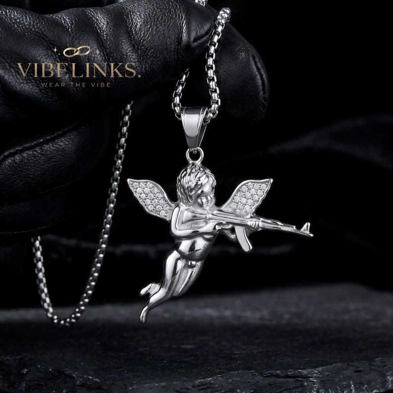 Detailed view of a gold tone angel pendant necklace with pavé CZ crystal wings in stainless steel, showing the sculpted Cupid face, body, and sparkling wing detail, a popular hip hop and festival jewelry accessory with 60cm chain.