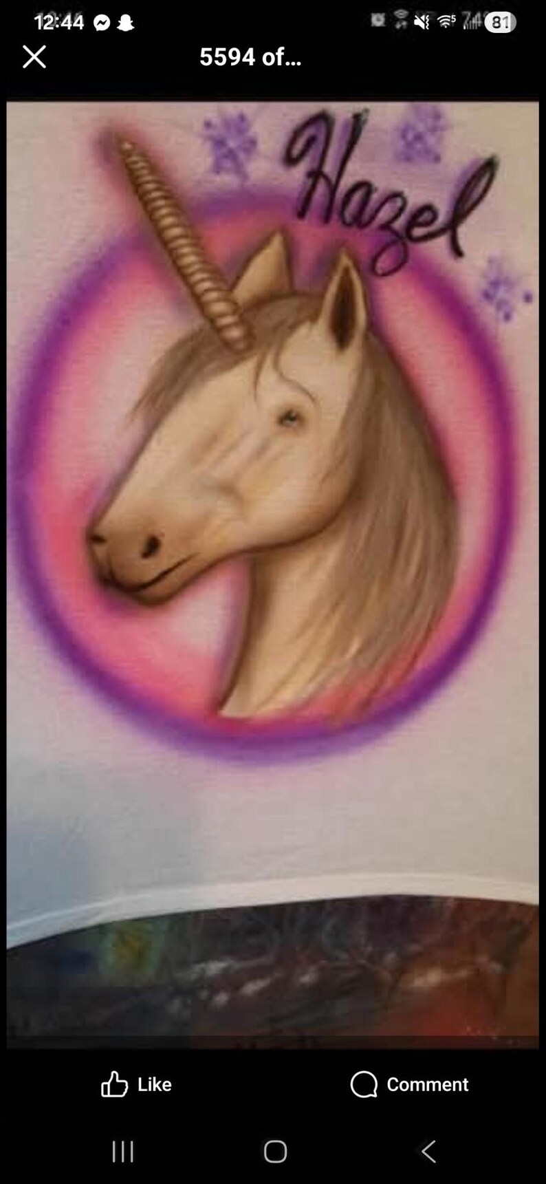 May include: A painted unicorn head with a spiral horn, within a pink and purple circle. The name "Hazel" is written in cursive above the unicorn. The artwork is on a white surface.