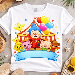 May include: A white short-sleeved t-shirt featuring a colorful graphic of a circus tent, a central clown character, and various animal friends including a yellow chick, a pink cat, a pig, and a bear, all holding heart-shaped balloons.