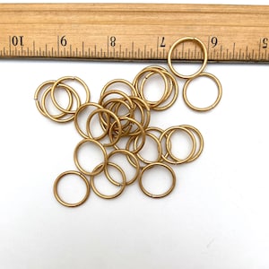 May include: A pile of 20 gold jump rings. The rings are about 1/2 inch in diameter.