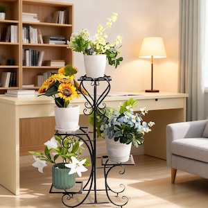 May include: A black metal plant stand with four tiers featuring scrollwork designs. The stand holds four potted plants: a white pot with yellow flowers, a white pot with sunflowers, a green ribbed pot with white lilies, and a grey pot with greenery.