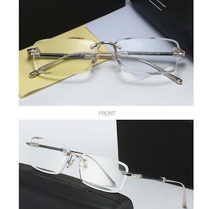 May include: Rimless eyeglasses with a gold and silver frame. The lenses are transparent. The image includes the text "GOLD/TRANSPARENT", "FRONT", and "45&deg;DISPLAY".