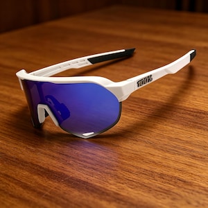 May include: White sports sunglasses with blue mirrored lenses. The sunglasses have a white frame with black accents on the arms and nose bridge. The brand name "100%" is printed on the right arm.