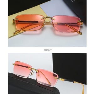 May include: Gold-framed sunglasses with gradient pink lenses. The rectangular lenses transition from a darker pink at the top to a lighter shade at the bottom. The image includes the text "GOLD/PINK", "FRONT", and "45&deg;DISPLAY".