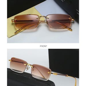 May include: Gold rimless sunglasses with gradient brown lenses. The rectangular lenses are set in a gold frame with a bridge and temples. The text "GOLD/TEA" is at the top of the image.