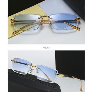 May include: Gold-framed rimless sunglasses with gradient blue lenses. The glasses have a rectangular shape and a gold bridge and temples. The text "GOLD/BLUE" is at the top of the image, and "FRONT" and "45&deg;DISPLAY" are also visible.