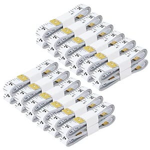 May include: A collection of twelve white flexible measuring tapes, each coiled and secured with a white paper band. The tapes feature black printed markings for inches and centimetres, with gold-coloured metal tips at the ends of each tape.