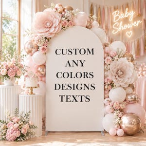 Può includere: Un pannello di sfondo ad arco con il testo nero CUSTOM ANY COLORS DESIGNS TEXTS, decorato con grandi fiori di carta rosa pallido, palloncini bianchi e oro rosa e composizioni floreali nei toni del rosa e della crema.