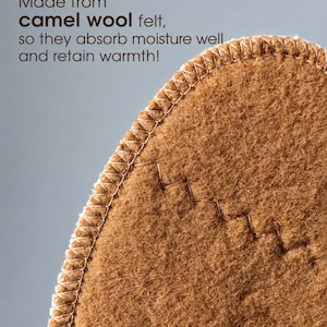 May include: A brown camel wool felt textile with a rounded edge featuring a white overcast stitch along the perimeter and a decorative zigzag stitch detail. The text reads: Made from camel wool felt, so they absorb moisture well and retain warmth!