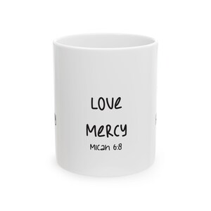 Può includere: Tazza in ceramica bianca con le parole "LOVE MERCY" in nero e il testo "Micah 6:8". La tazza, di forma cilindrica, presenta un design semplice, adatta per caffè, tè o altre bevande.