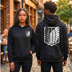 Könnte beinhalten: Schwarzer Kapuzenpullover mit einem weißen Emblem auf der Vorder- und Rückseite. Das vordere Emblem ist ein stilisiertes Flügeldesign. Auf der Rückseite des Sweatshirts ist eine größere Version desselben Emblems abgebildet. Das Sweatshirt hat eine Vordertasche und eine Kapuze.