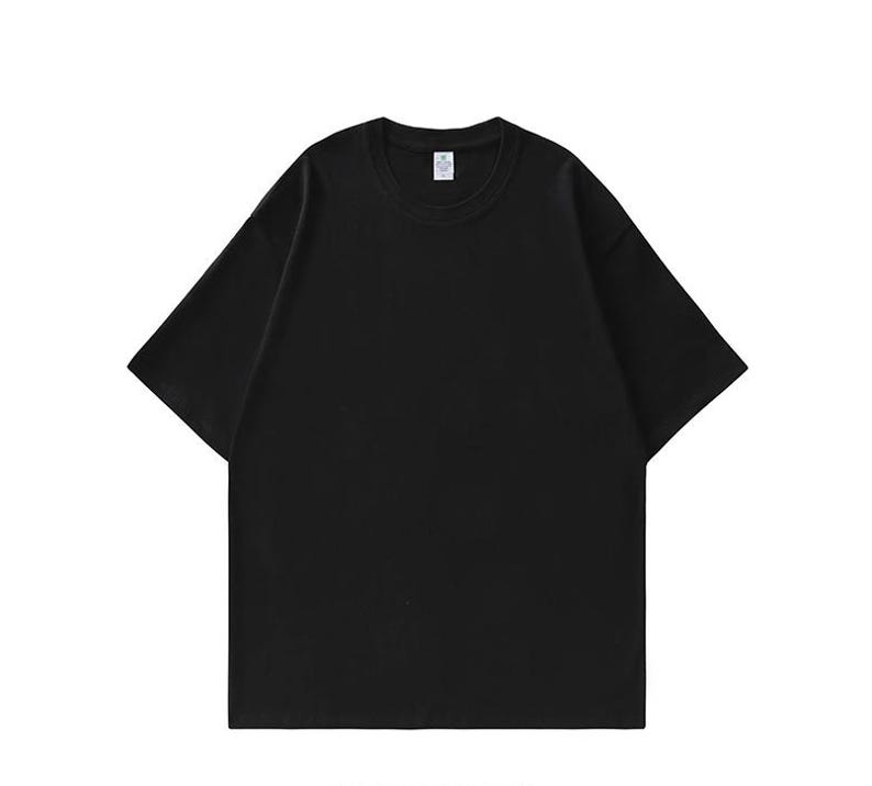 May include: A solid black t-shirt with a crew neck and short sleeves. The shirt has a relaxed fit and appears to be made of a soft, comfortable material. The tag is visible on the inside of the collar.