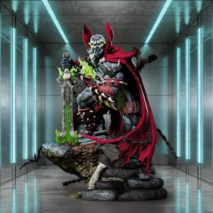May include: A detailed statue of Spawn, a comic book character, in a dynamic pose. The figure is clad in a dark, textured suit with a flowing red cape. He holds a glowing green sword, and the base is a detailed rock formation.