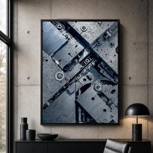 Może przedstawiać: Prostokątna dekoracja ścienna w czarnej ramie przedstawiająca kontrastową, industrialną kompozycję metalowych płyt, zazębiających się kół zębatych i elementów mechanicznych w odcieniach ciemnej szarości, srebra i głębokiego błękitu.