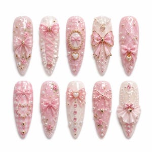 Puede incluir: Un juego de diez uñas postizas en forma de almendra en tonos rosa y blanco, con adornos en 3D que incluyen lazos, corazones, perlas, rosas y patrones de cuadros. Cada uña está decorada con dijes intrincados, purpurina y detalles de encaje.