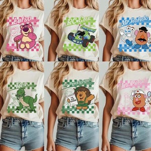 Pode incluir: Uma cole&ccedil;&atilde;o de seis camisetas bege com gr&aacute;ficos de personagens de desenhos animados. Cada camisa tem um design diferente com personagens como Lotso, RC Car, Mr. Potato, Rex, Mr. Pricklepants e Mrs. Potato, com texto.