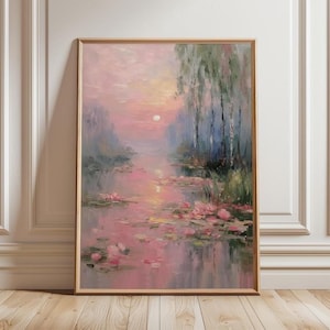 May include: A framed oil painting depicts a serene waterscape at sunset. The artwork features pink and purple hues, with lily pads and trees reflected in the water. The sun is a soft white orb in the sky.