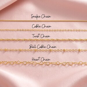 Puede incluir: Una selecci&oacute;n de collares dorados sobre una superficie de sat&eacute;n rosa. Los collares incluyen una cadena de serpiente, una cadena de cable, una cadena trenzada, una cadena de bolas y una cadena de coraz&oacute;n. Cada estilo de cadena est&aacute; etiquetado.