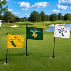Peut inclure: Trois drapeaux de golf personnalisés sur un parcours vert. Les drapeaux sont jaunes, verts et blancs, chacun avec un nom et un contour d'état différents. Un golfeur est en arrière-plan, en train de balancer un club de golf.