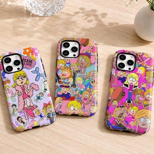 May include: Three smartphone cases featuring cartoon character graphics. The left case is light purple with various character poses and the text Lizzie McGuire. The center case has a collage of character scenes. The right case is bright pink with character patterns.