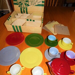 May include: A vintage Little Hostess Party Set in its original box. The set includes a red teapot, four teacups, four saucers, four plates, and a yellow plate. The set is made of plastic and is in good condition.